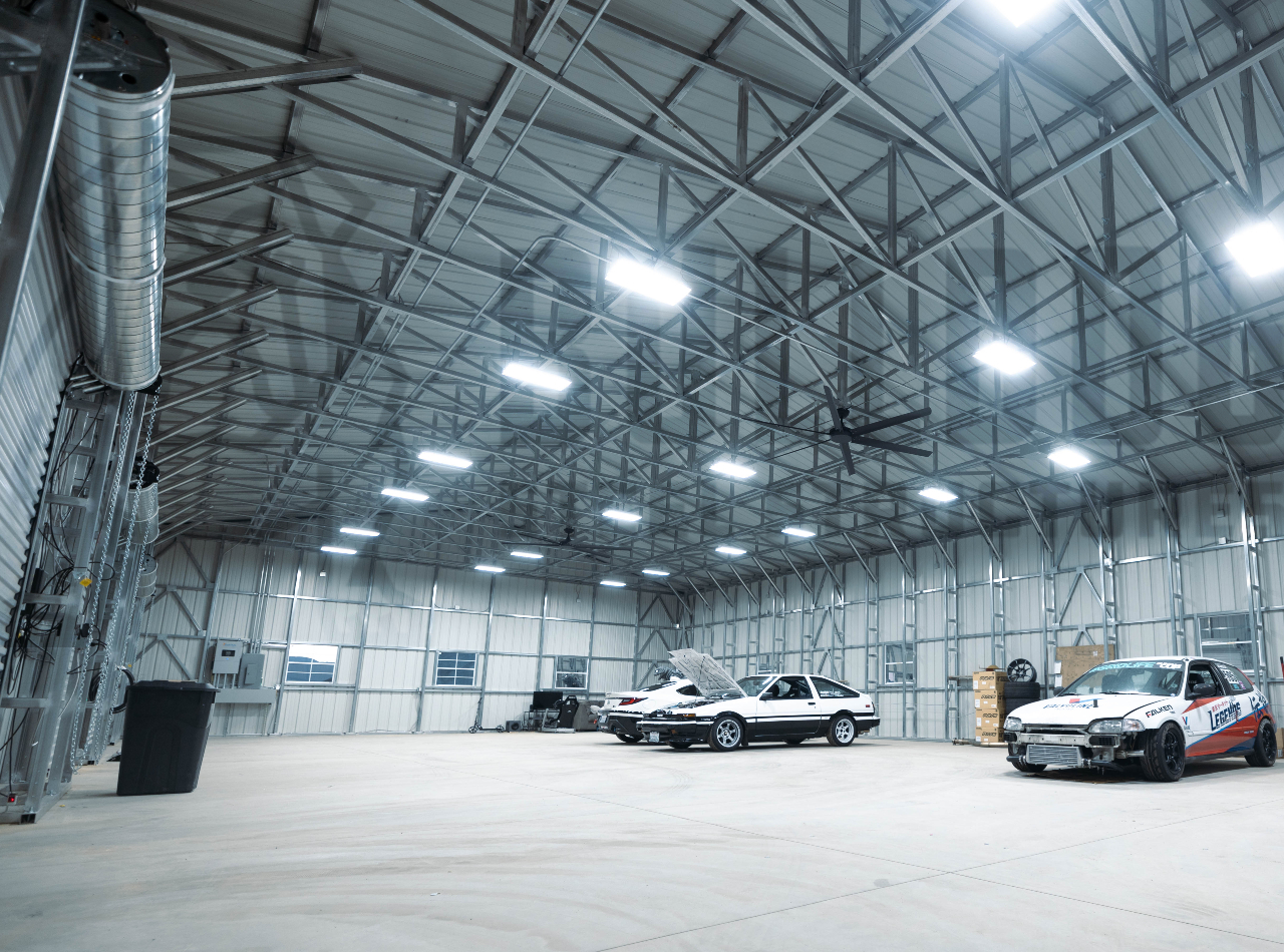 Interior of a large steel garage with 3 cars